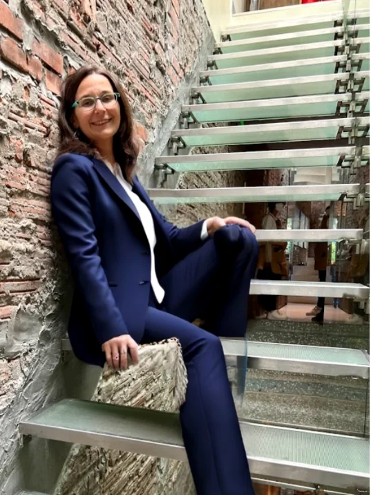 Missy Wanstall in a navy suit on an open staircase